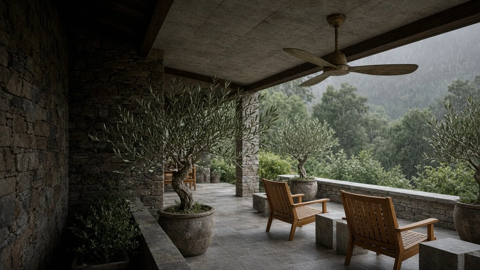 A covered stone porch with a weathered-bronze ceiling fan above teak lounge chairs